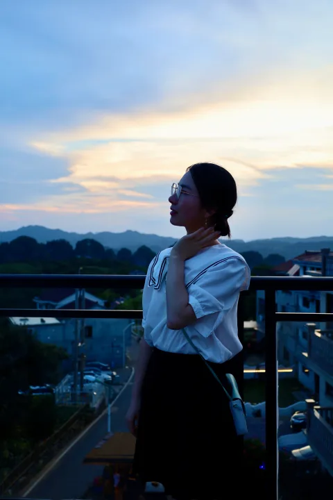 夕阳下的栏杆边留影，身后是山色与云光